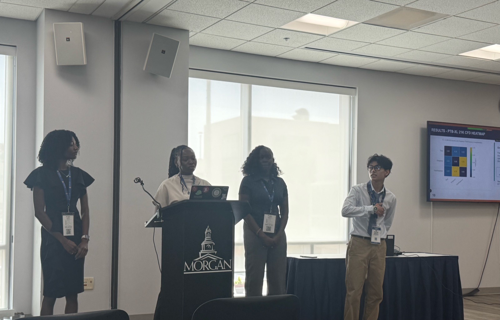 Team presenting SAIRI drift-classification results, including a PTB-XL heatmap, at a podium branded with the Morgan State seal.